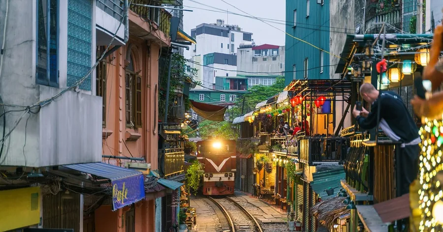 Đoàn tàu chạy qua giữa nhà dân và quán cà phê trên phố đường tàu Hà Nội